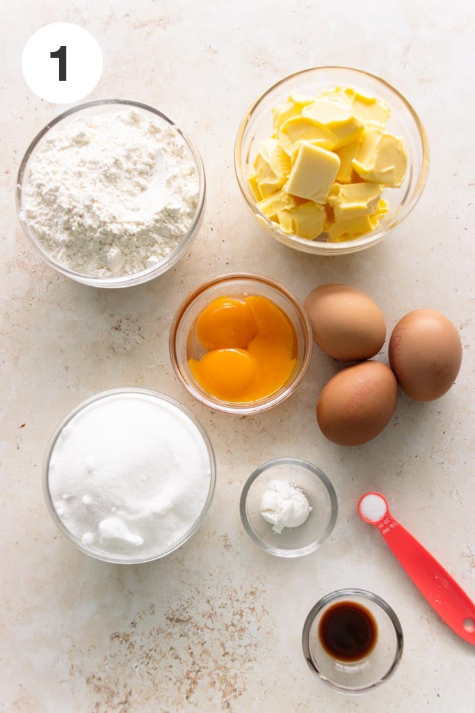 Preparing the ingredients to make pound cake - cake flour, butter, sugar, whole eggs and egg yolks, baking powder, vanilla extract and salt.