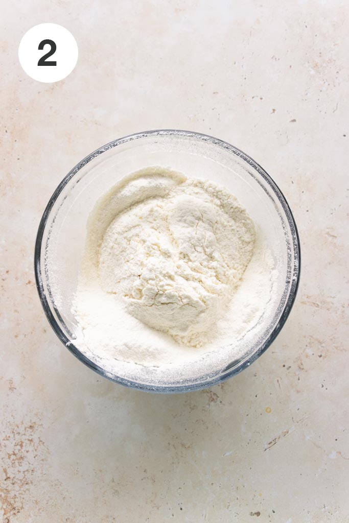 Pound cake recipe step: Sifted flour and salt mixture in a glass mixing bowl.