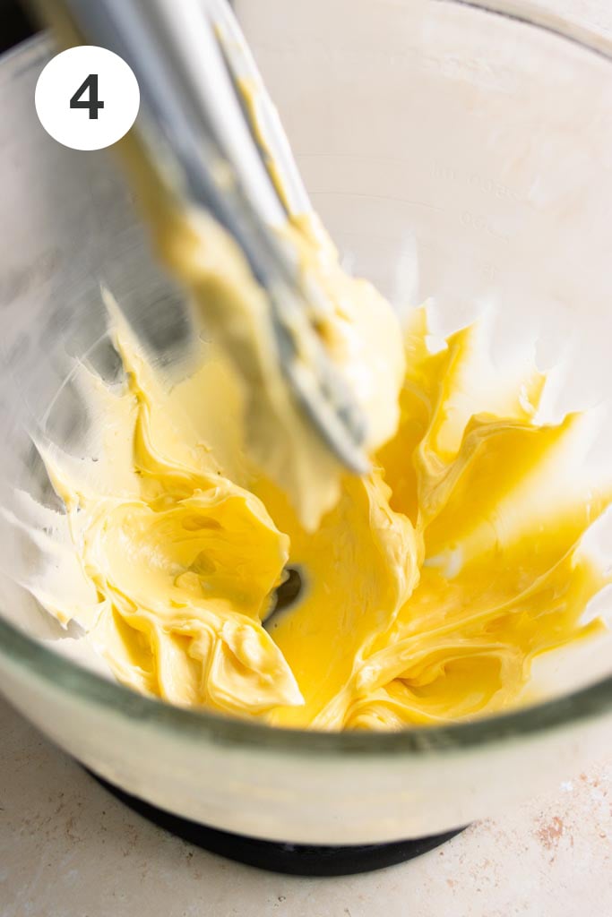 Pound cake recipe step: Whipped butter in the glass bowl of a stand mixer.