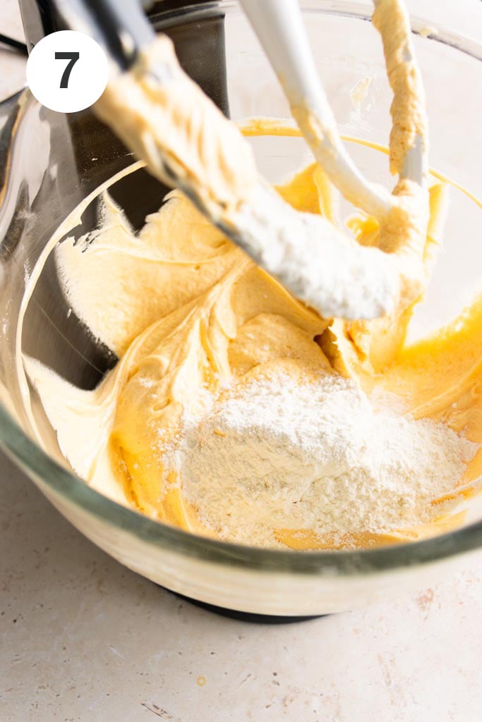 Adding the sifted flour to the creamed butter, sugar, and eggs mixture.